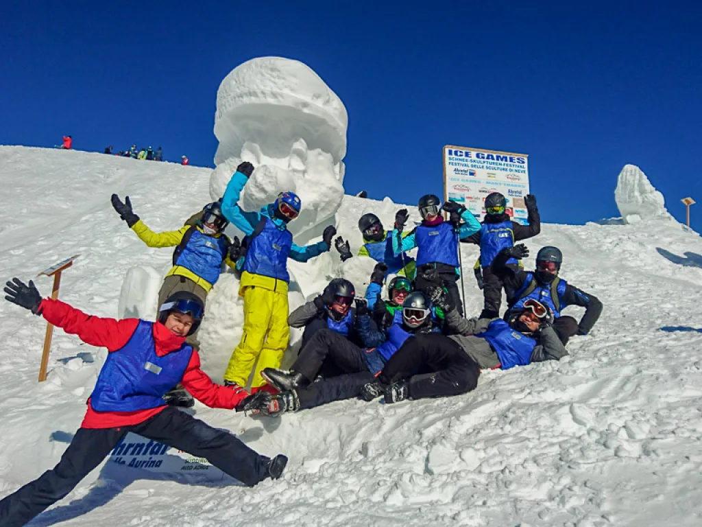 Gruppe posiert vor großen Schneeskulpturen.